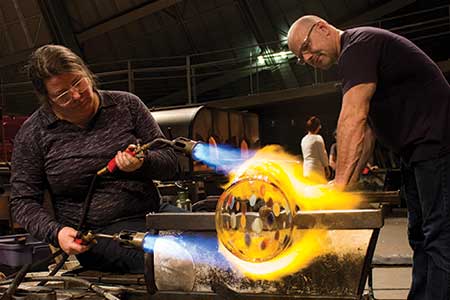 Photo of 2 glass artists working on a new creation